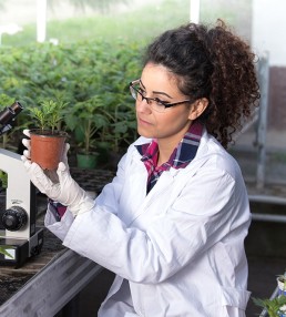 lady in lab coat with plant